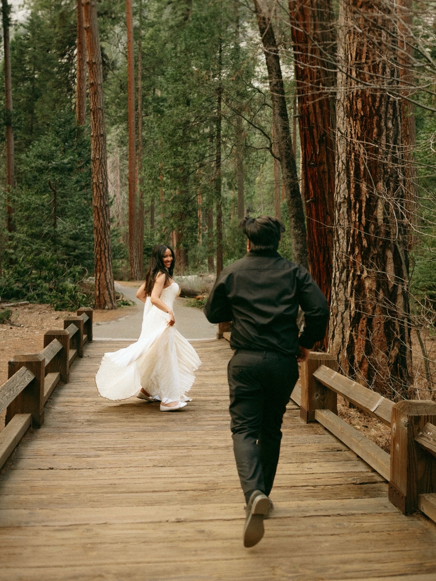 Tamara and Christian playing on a wooden bridge in the Yosemite forest